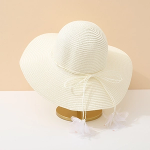 Elegant white straw hat with large brim, ribbon bow and floral tassels for beach wear