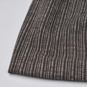 Macro shot of striped ribbed knit fabric in brown and grey tones for winter beanies