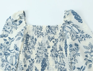 Detail of square neckline and puff sleeves on blue floral Toile de Jouy midi dress