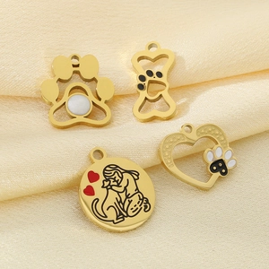 Detail of 18k gold stainless steel pet charms featuring paw prints and bone designs