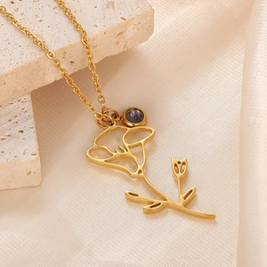 Close-up of 18k gold plated flower pendant with a deep blue sapphire-colored stone