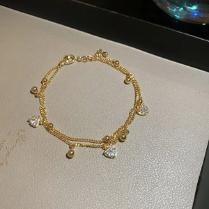 Macro shot of 18k gold plated double-layer bracelet featuring sparkling heart zircons