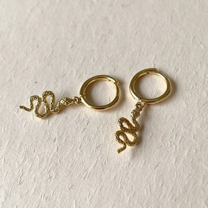 Close-up of golden S925 sterling silver snake earrings with detailed scale texture