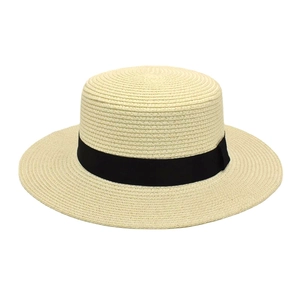 Detail of classic beige boater straw hat with black ribbon and fine woven texture