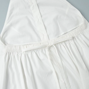Close-up of white cotton maxi dress featuring elastic waist, drawstrings and button placket