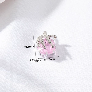 Detail view of heart bow pendant with pink zircon, measuring 19.1mm by 13.73mm