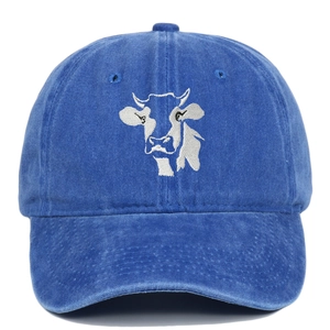 Close-up of embroidered white cow head on vintage washed denim blue baseball cap texture