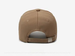 Detail of the tan baseball cap featuring an adjustable strap with a metal buckle