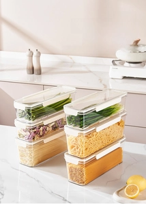 Stack of clear PET food containers for noodles with white airtight lids in a modern kitchen