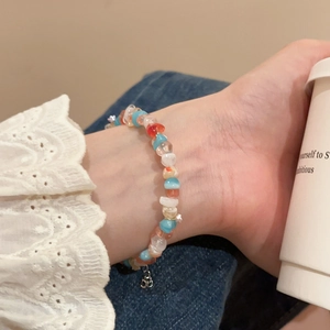 Close-up of handmade beaded bracelet with colorful stones on a wrist in a cozy setting