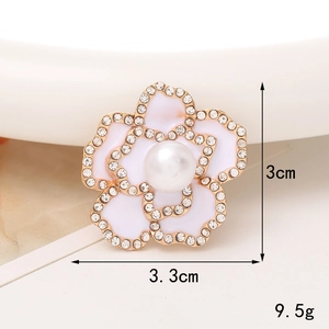 Vue macro d'un accessoire camélia de 3,3 cm avec pétales en émail blanc et centre en perle