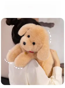 Close-up of fluffy golden Labrador plush toy with red collar and bell held by a person