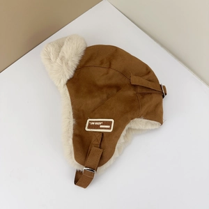Close-up of brown suede trapper hat showing thick faux fur lining and metal buckle detail