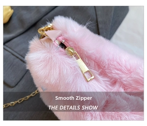Detail showing smooth gold zipper and soft pink faux fur texture on plush heart bag