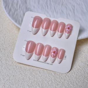 Pink French ombre press-on nails in almond shape with 3D flower accents and pearls