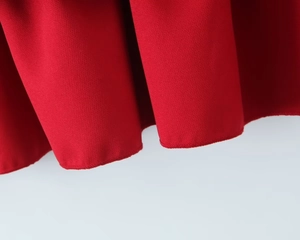 Detail shot of the ruffled hem on the red tiered dress showing woven fabric texture