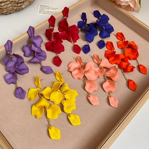 Detailed view of matte flower petal tassel earrings in six vibrant colors on a tray
