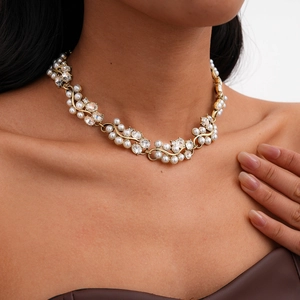 Detail of vintage gold necklace with baroque pearls and rhinestones on model neck