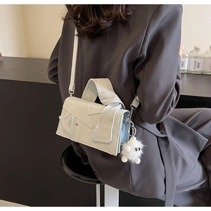 Détail d'un sac à bandoulière carré gris clair avec un design de poignée nouée élégant
