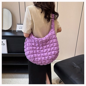 Detail showing the quilted bubble texture and large capacity of the purple hobo shoulder bag