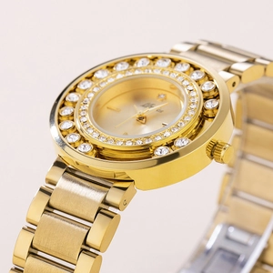 Close-up of gold-tone ladies watch featuring crystal bezel and metallic strap