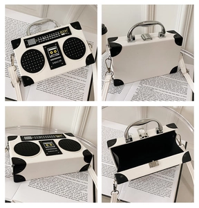 Detail view of white radio shaped crossbody bag with silver handle and textured leather