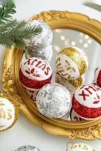 Macro detail of white frosted Xmas ornament with red and gold glitter on a mirror tray