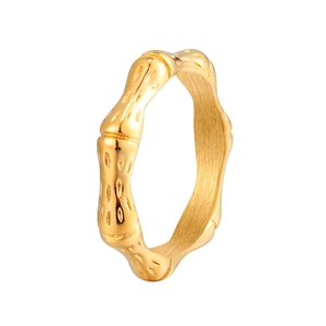 Makroaufnahme eines goldenen Bambusrings mit gebürsteter Textur und Metallgelenken