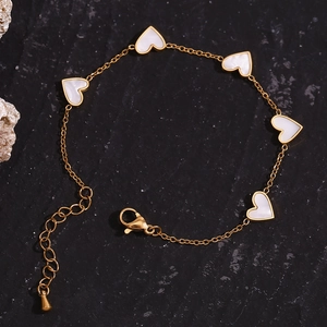 Detailed macro view of 18K gold plated chain featuring five white shell heart pendants