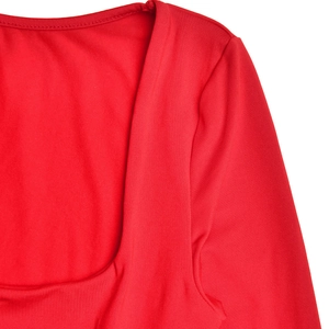 Détail du décolleté carré et de la texture du tissu en maille de cette robe rouge longue