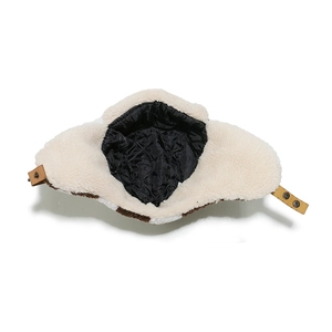 Detail of winter trapper hat showing black quilted lining and white sherpa fleece trim