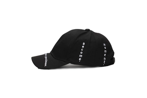 Detail of white embroidery with motivational quotes on a black cotton baseball cap side