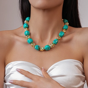 Detail of turquoise beads and gold irregular metallic beads on a bohemian necklace