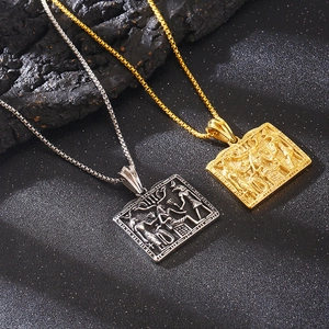 Detail of square gold and silver Egyptian pendants with ancient hieroglyphic carvings
