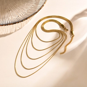Détail du collier à quatre couches en maille serpent dorée avec fermoir mousqueton