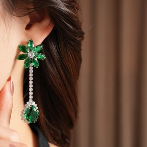 Detail of silver drop earring with green flower top and large pear-cut zircon pendant
