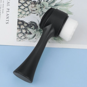 Detailed view of dual-sided facial brush with soft bristles and silicone massage pad
