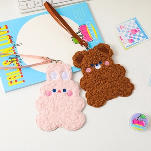 Detail of plush bunny and bear card holders with embroidery and leather lanyards