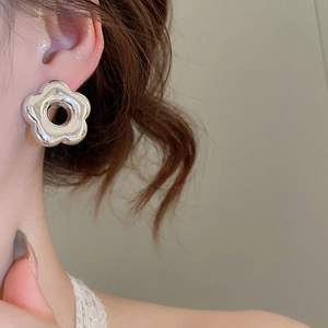 Gros plan de boucles d'oreilles fleurs en argent brillant sur un modèle élégant