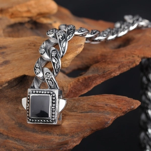 Bracciale vintage in acciaio al titanio con gemma nera e incisioni floreali di rose