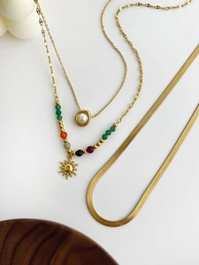 Detailed set of three gold-plated necklaces with sun pendant, pearl, and sleek snake chain
