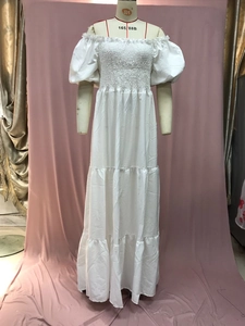 Detail of smocked bodice and puff sleeves on white off-shoulder tiered maxi dress