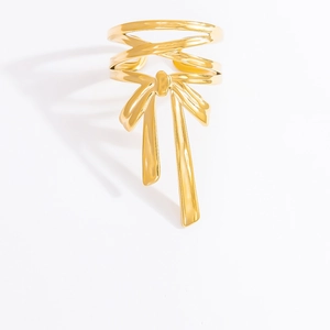 Elegant gold bow ring with fluid lines and metallic finish on white background