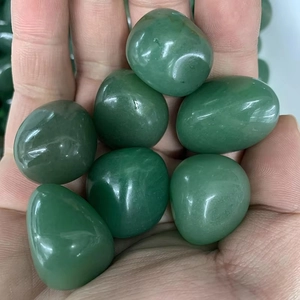 Close-up of polished green natural river stones held in hand for aquarium decoration