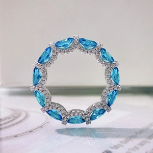 Macro shot of silver ring pendant with marquise blue stone and clear pavé crystals