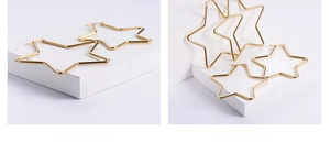 Nahaufnahme übergroßer sternförmiger Goldohrringe mit minimalistischem Drahtrahmen-Design
