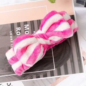 Detail of pink and white striped plush bow headband made of soft coral fleece