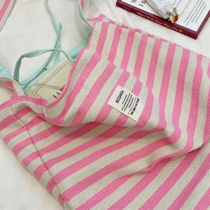 Détail du sac cabas en toile à rayures roses avec sangle vert menthe et étiquette