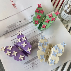 Elegant acetate butterfly hair claws with 3D flower details in green, purple, and beige