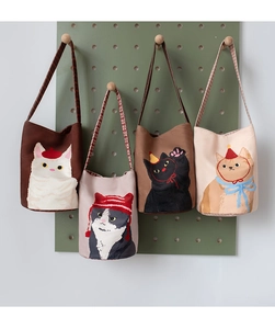 Detail of four canvas bucket bags featuring cute cartoon cat prints and plaid straps